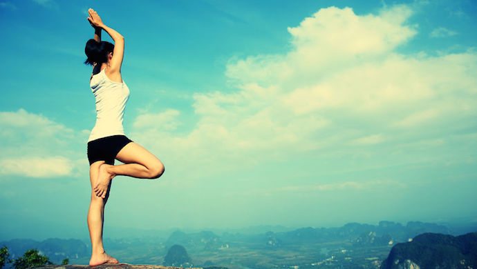 50011543 - yoga woman mountain peak