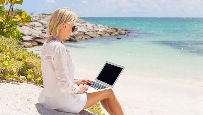 39705075 - businesswoman working with computer on the beach