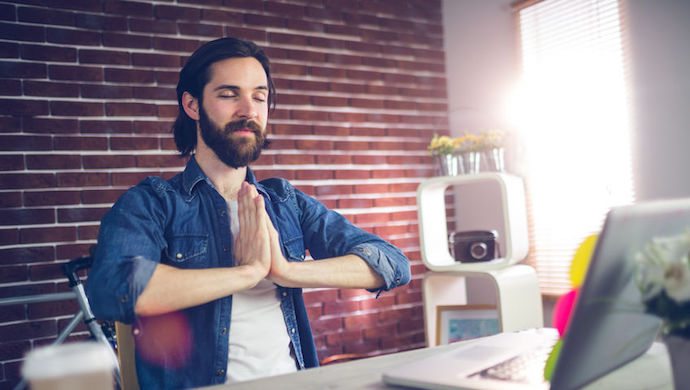 45535961 - businessman with hand clasped doing yoga in creative office