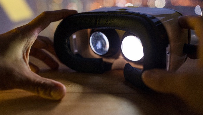 Male hand holding VR device at night